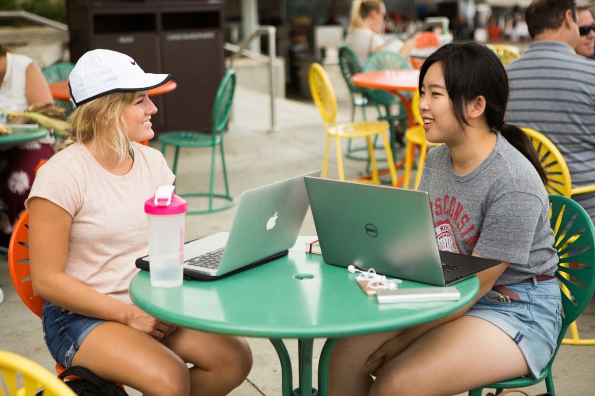 Two uw-madison students with their computers studying on the Terrace