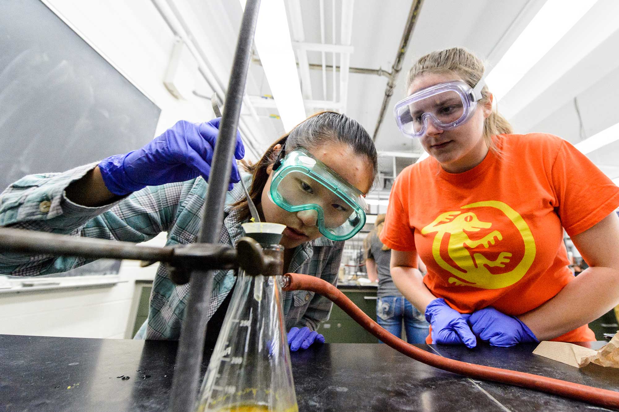 students working in a lab on a table with a beaker