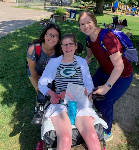 nursing students posing with an Easter Seals camper in a wheelchair at camp