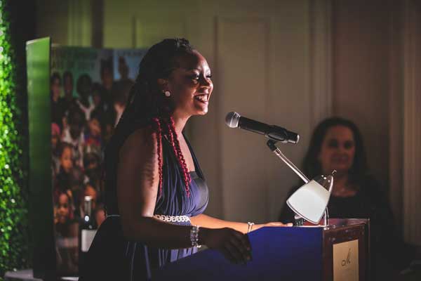 Keena Atkinson speaking at a podium at the Odyssey/Madion Club gala