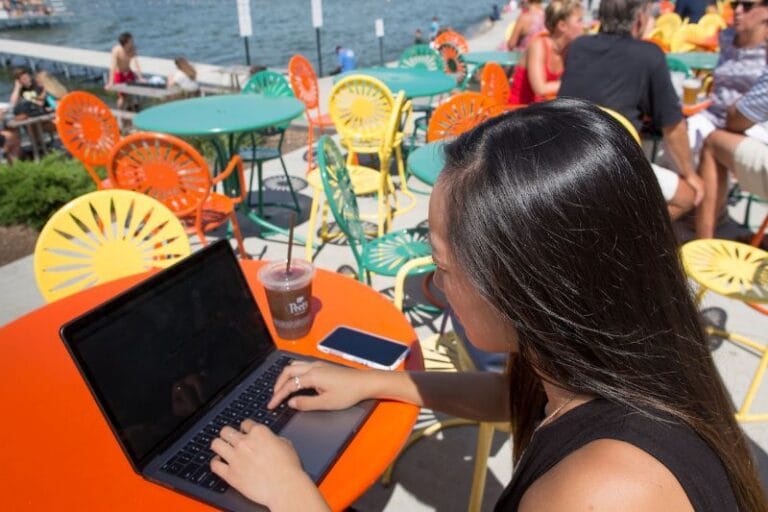 student sitting on the memorial union terrace on her computer