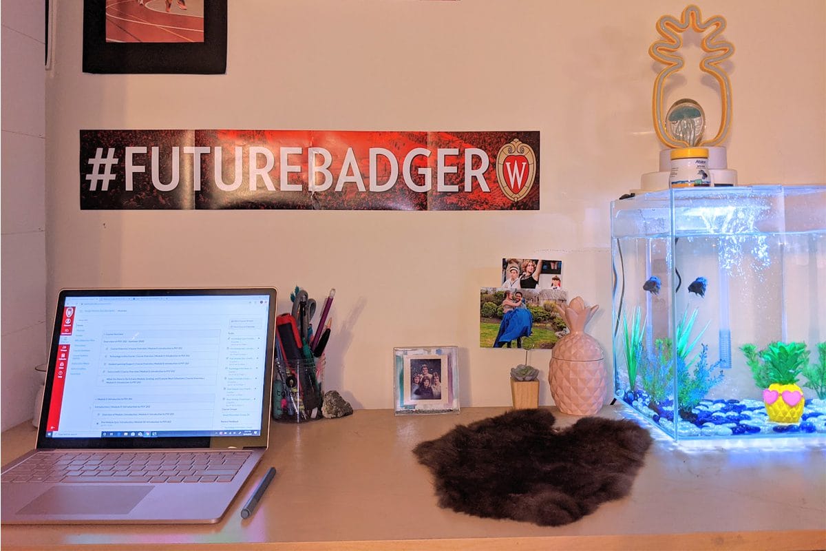 Desk with laptop and fish tank, and #FutureBadger banner on the wall 