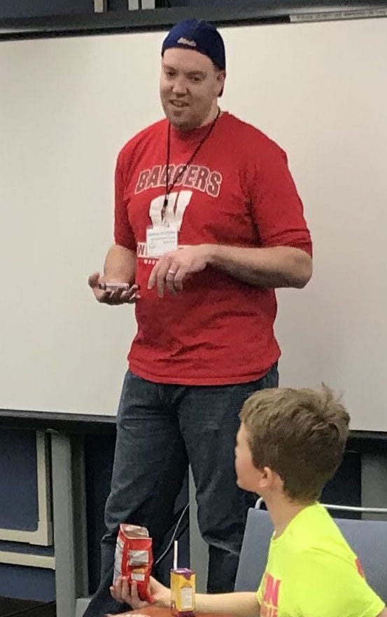 WCATY instructor Andrew Wolfgram standing at front of classroom, one student in immediate foreground