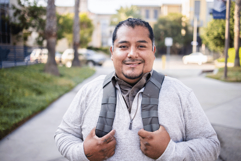 A latino man smiling at the camera.