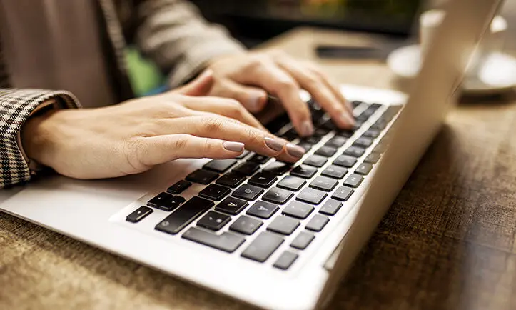 Hands on a laptop computer, typing