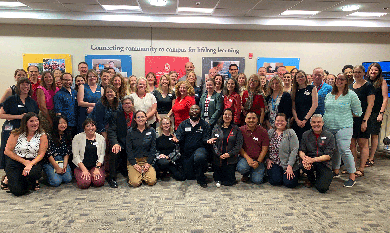 Large group of DCS staff standing and smiling, with chancellor in the center of the group