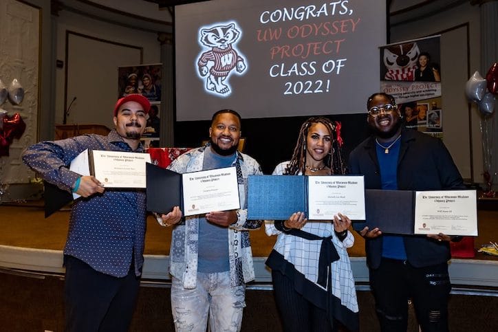 Odyssey Project graduates Brandyn Bess, Ontario Frazier, Michelle Lee Mack and Will Nunn III hold up their certificates at the graduation ceremony.