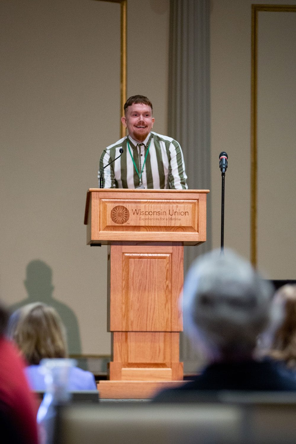 Smiling student speaks at podium in UW-Madison Memorial Union 