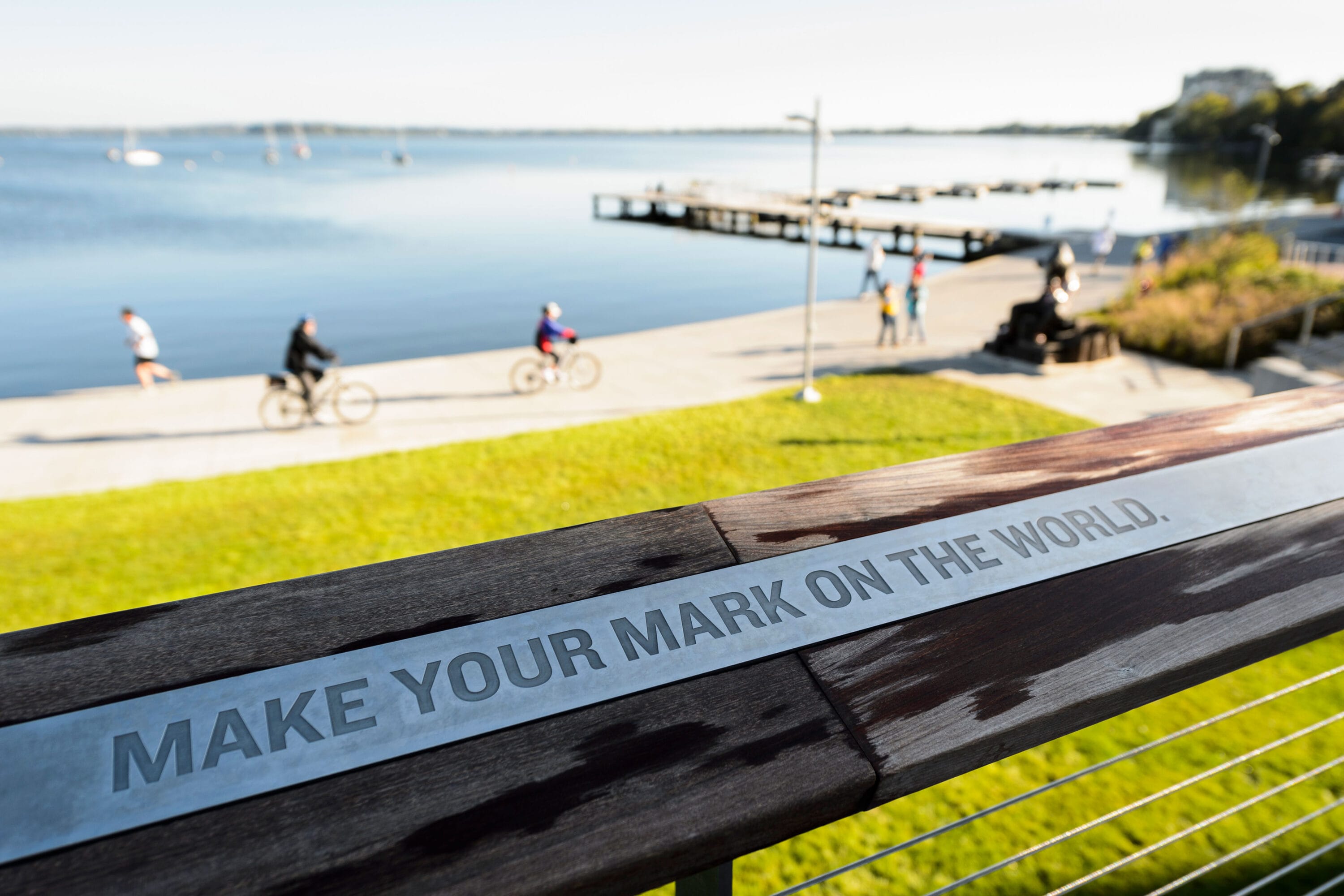 The phrase make your mark that has been carved into a wooden railing.