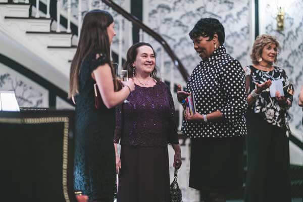 Emily Auerbach chatting with guests at the madison club fundraiser for odyssey