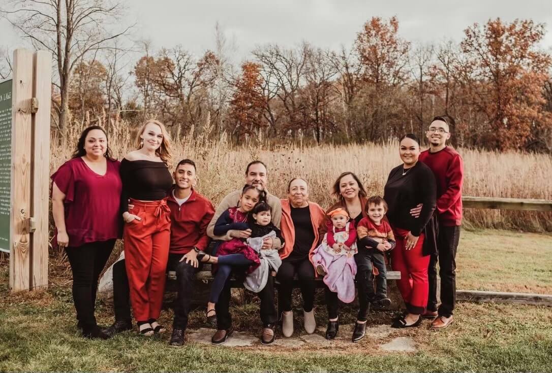 family of Jesus Garza Noriega standing together for a photo in front of a field and forest