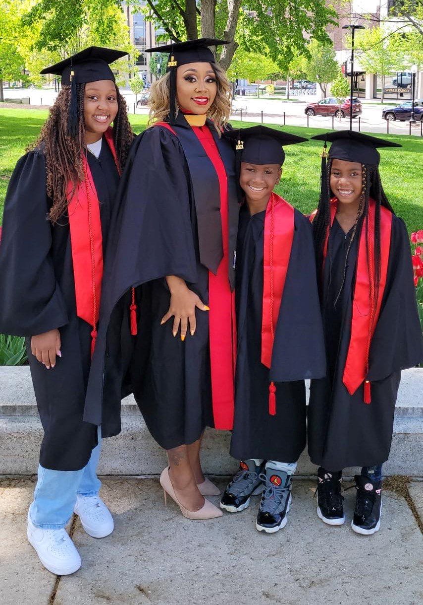 Dominque Christian standing in cap and gown with her children