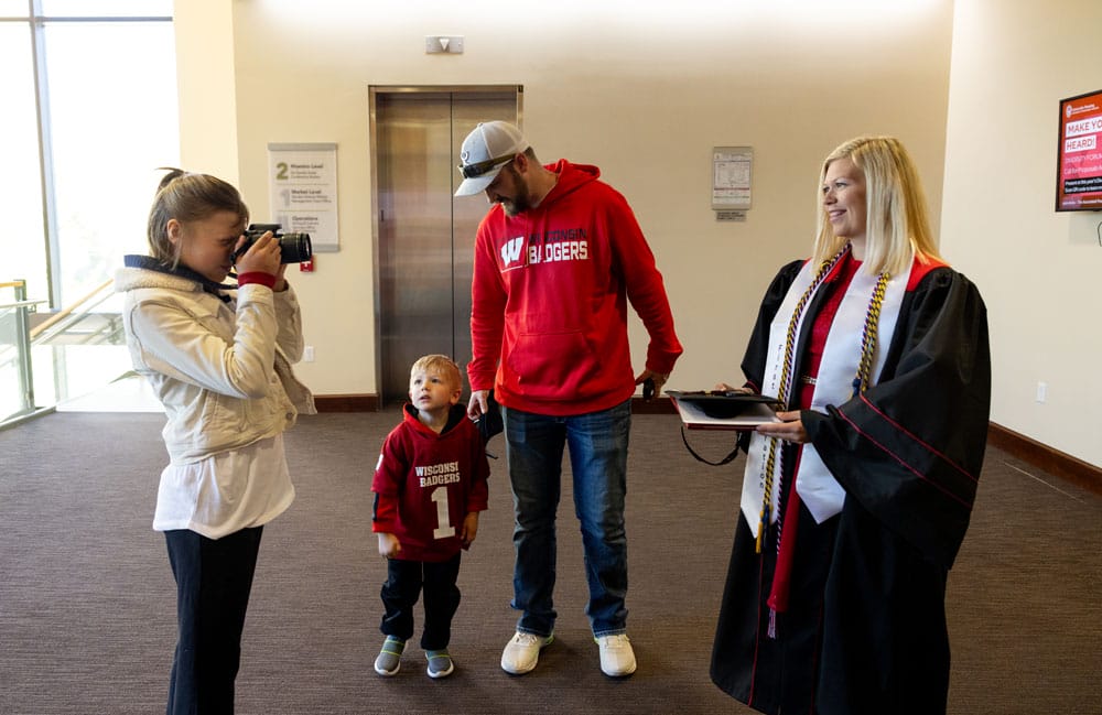 Kristy in her graduation gown getting photographed