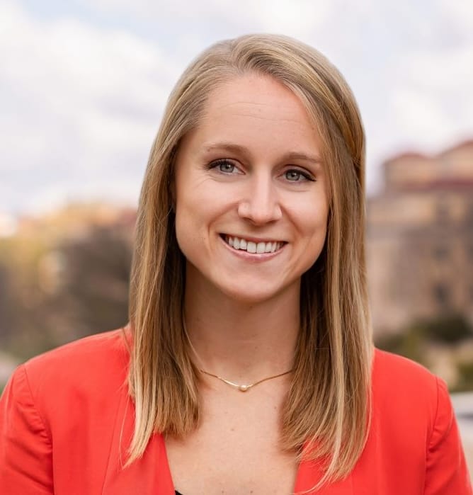 Headshot of Michelle Jackson, who has long blonde hair and is wearing a red blazer and gold necklace.