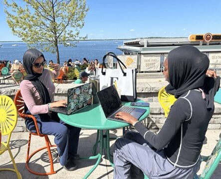 Farhiyo Ali sitting with a friend at a table on the terrace