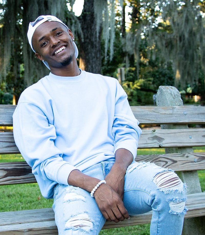 Keith Miller sitting on a bench smiling