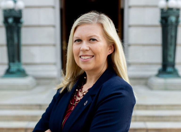 Professional headshot of Kristy Jorgensen in front of Wisconsin State Capitol building.