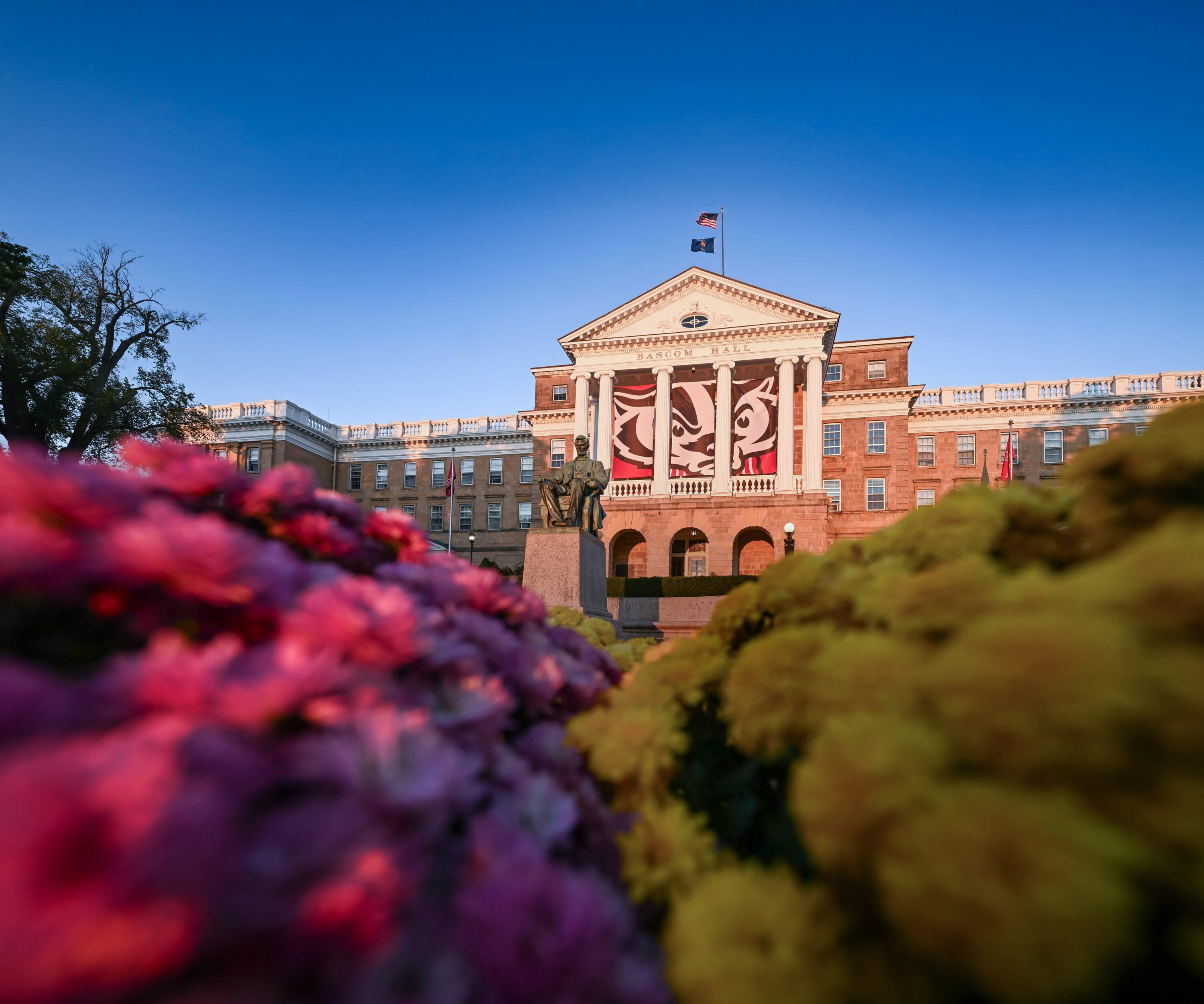 The exterior of Bascom Hall with flower bushes in the foreground