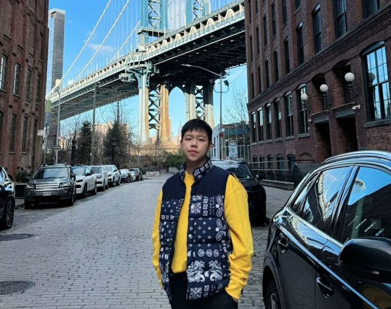 Student Jinhgao Zhou standing in front of a bridge