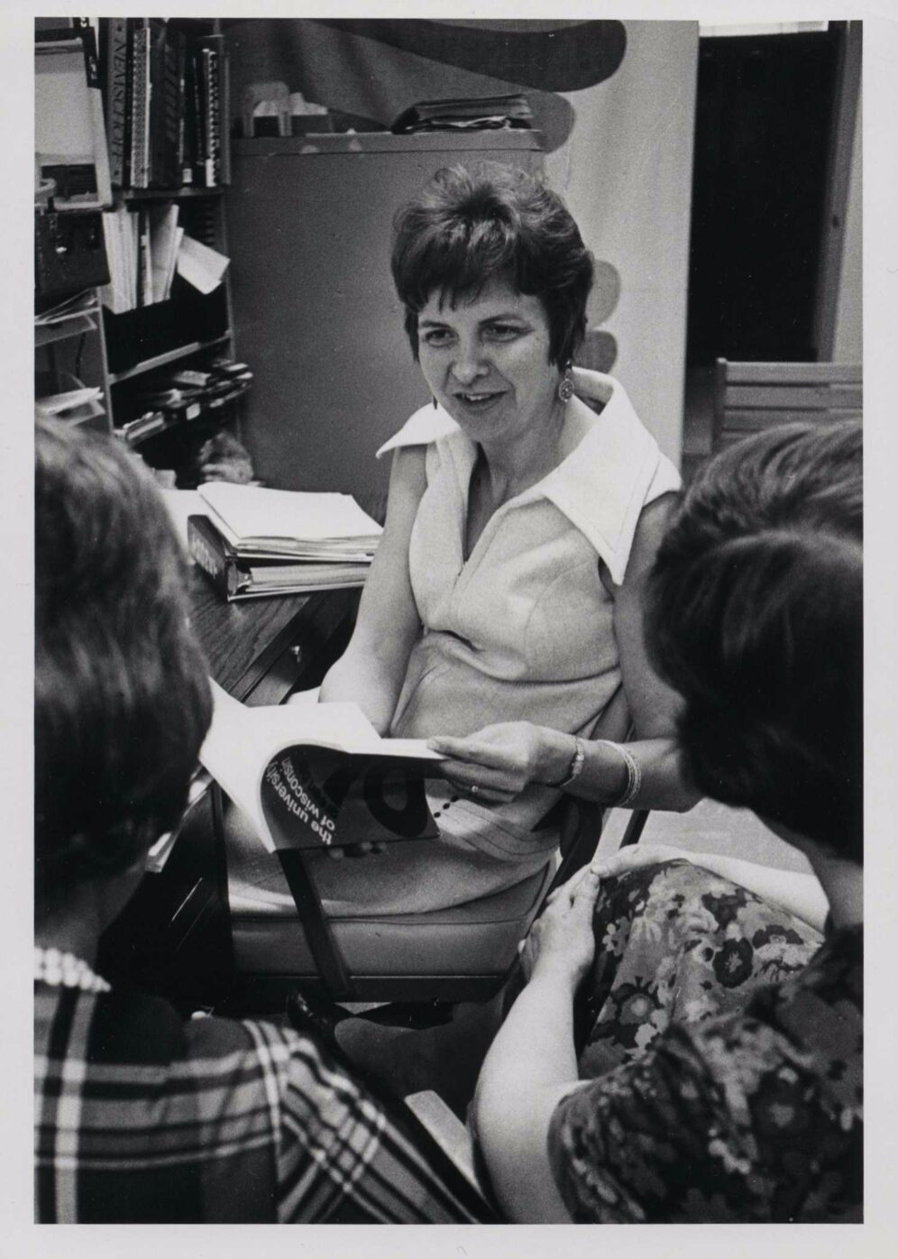 Marge Engelman in her office, counseling two students