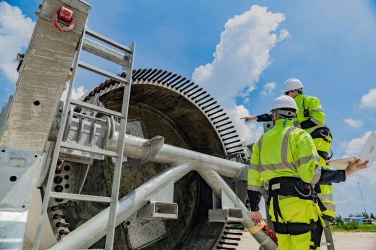 Two engineers on the field looking over a piece of equipment
