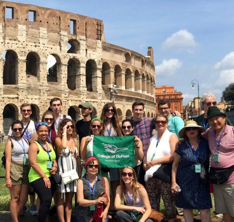 Mirta and language students posing for a group photo in front of the Colosseum