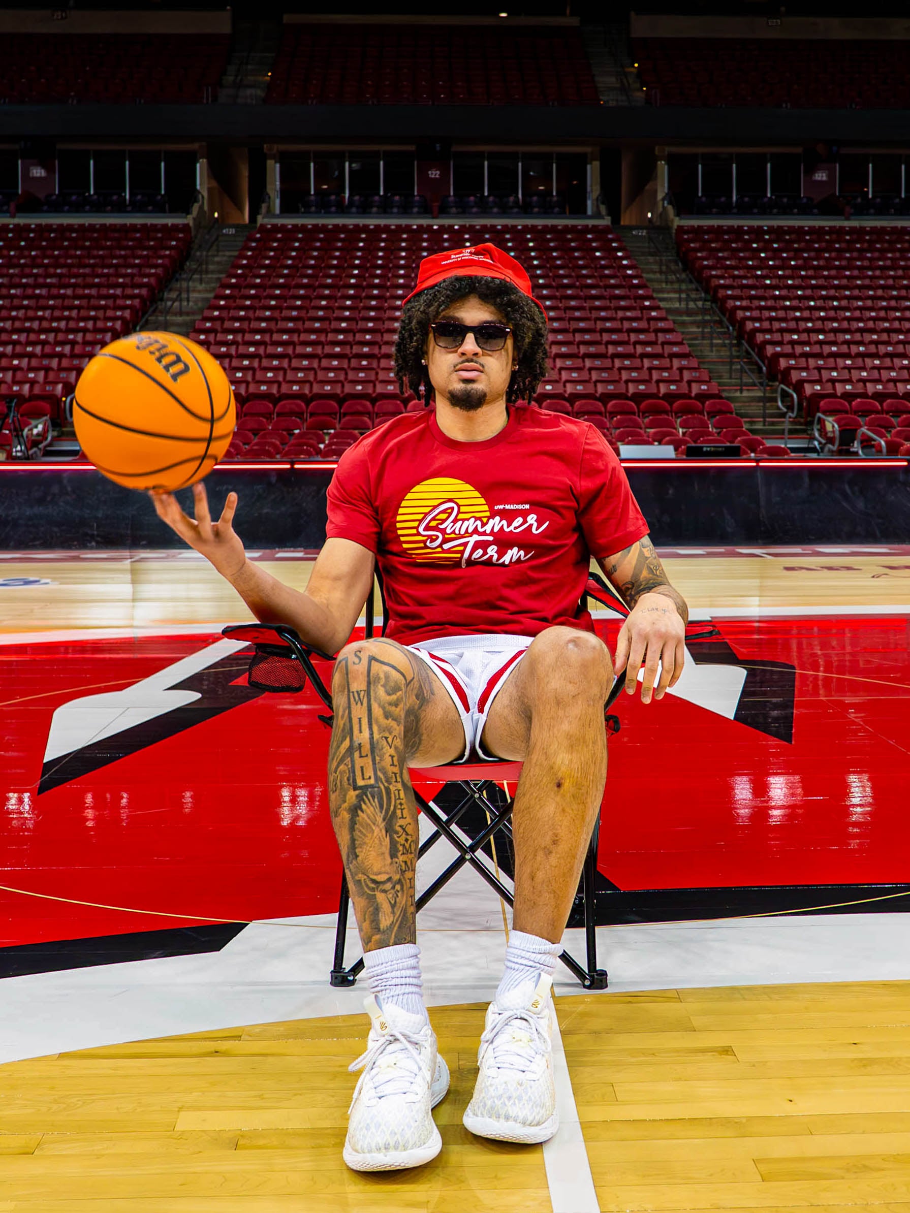 Braeden Carrington poses for a picture while wearing sunglasses and tossing a basketball in the air.