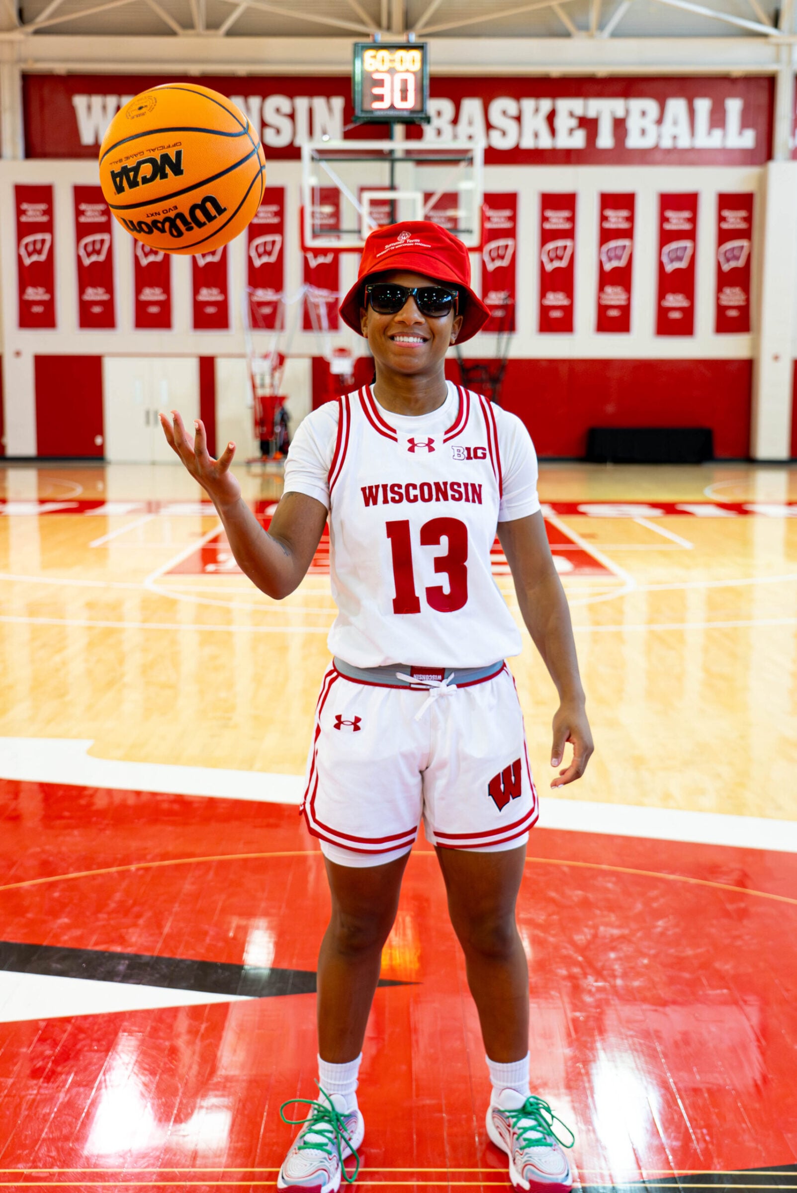 Ronnie Porter poses for a picture while wearing sunglasses and tossing a basketball in the air.