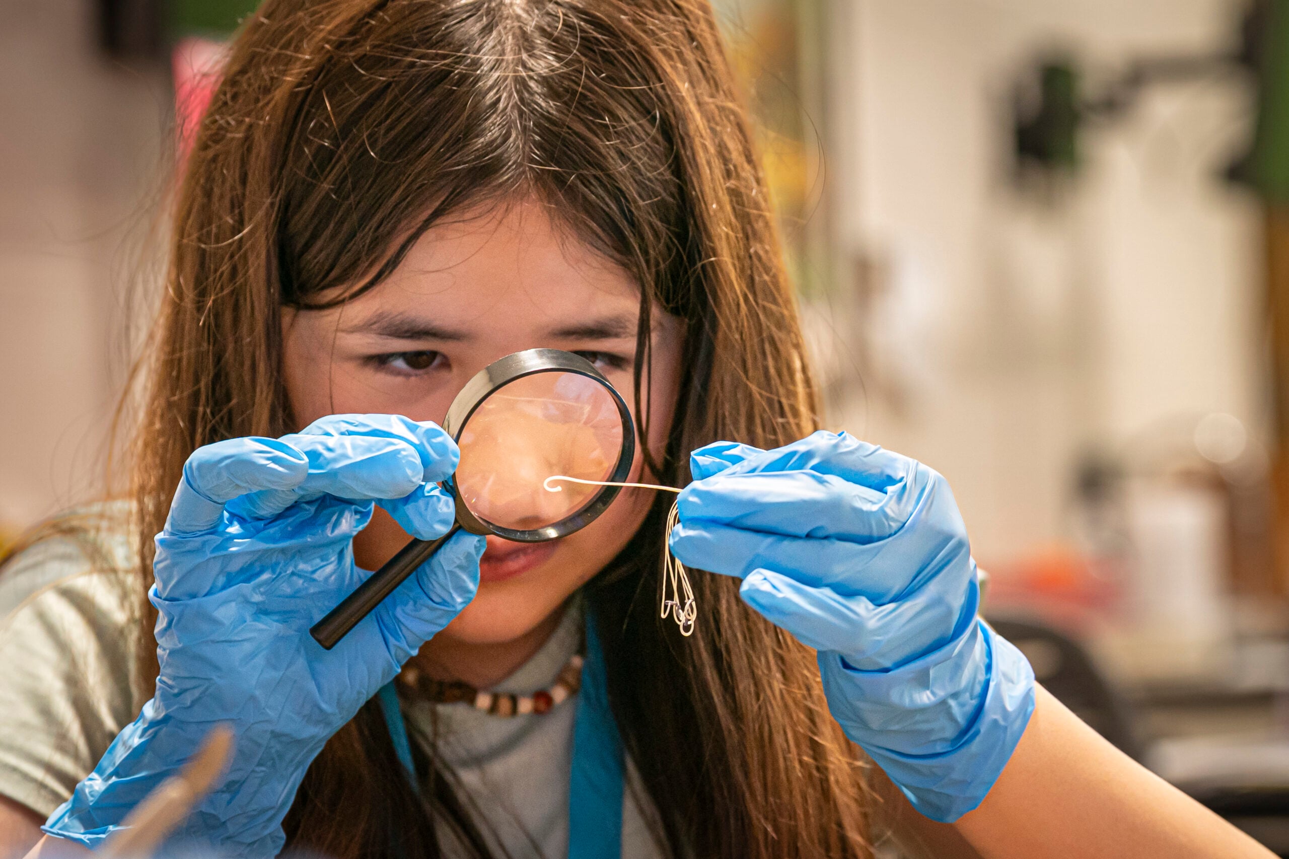 Child using magnifying glass to examine specimen