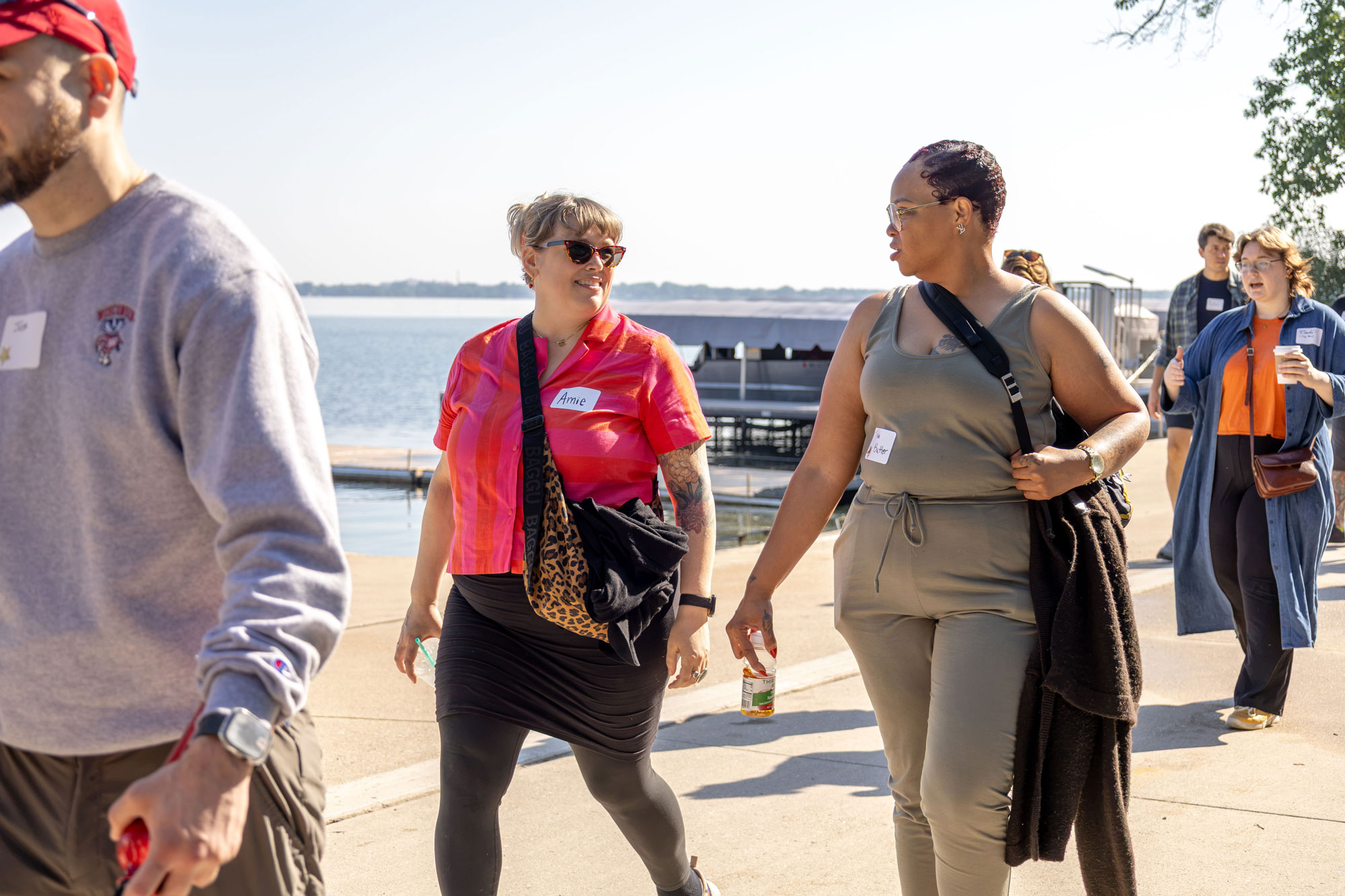 Incoming student Tisha Butler (right, in green) chats with alum Amie Swanson (left, in red) during the walk. Swanson later advised students to build relationships with professors and career advisors to unlock internship opportunities, adding: “It felt good to go back to school to show my kids that it can happen. It doesn’t matter how old you are; you can start or restart any time.”