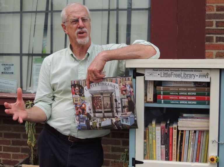 Rick Brooks standing next to a Little Free Library